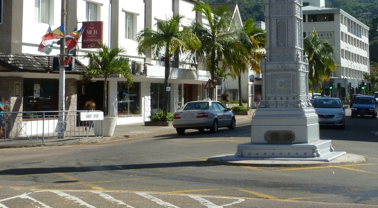 塞席爾維多利亞鐘樓路口，行人護欄旁白底ALBERT STREET街牌與後方街道。