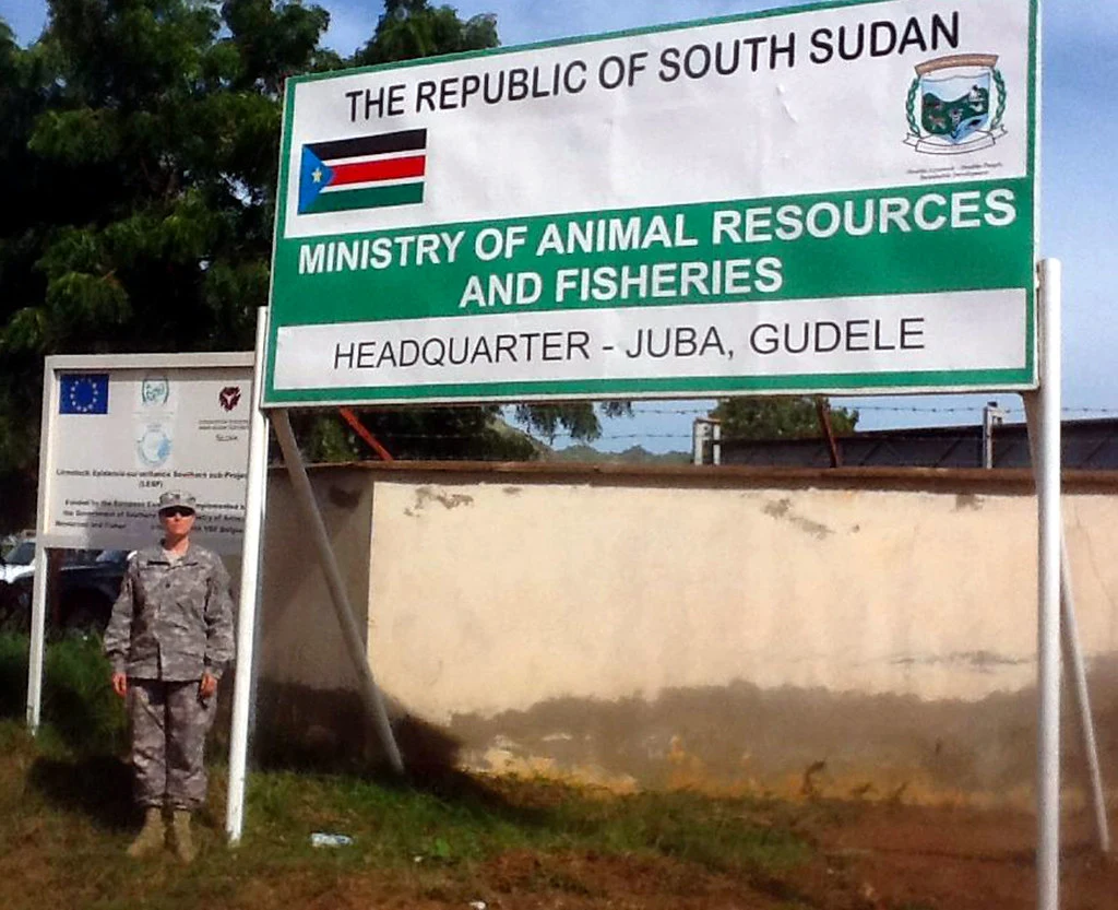 朱巴古德勒實拍入口牌，機構名稱下寫HEADQUARTER - JUBA, GUDELE，列出地方地址層級。