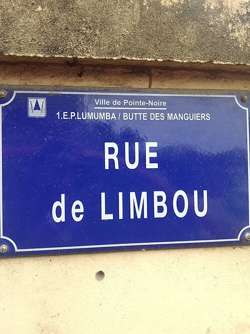 黑角的實拍街牌或門牌。牌上寫RUE de LIMBOU,頂端另列Ville de Pointe-Noire及1.E.P.LUMUMBA / BUTTE DES MANGUIERS。