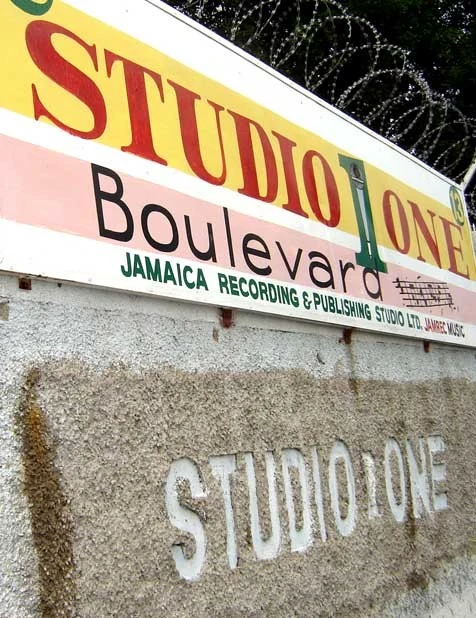 京斯敦街名標記。上牌可讀STUDIO ONE Boulevard，下方小字為JAMAICA RECORDING & PUBLISHING STUDIO LTD.；牆面另有STUDIO ONE浮字，僅上牌包含道路類別。