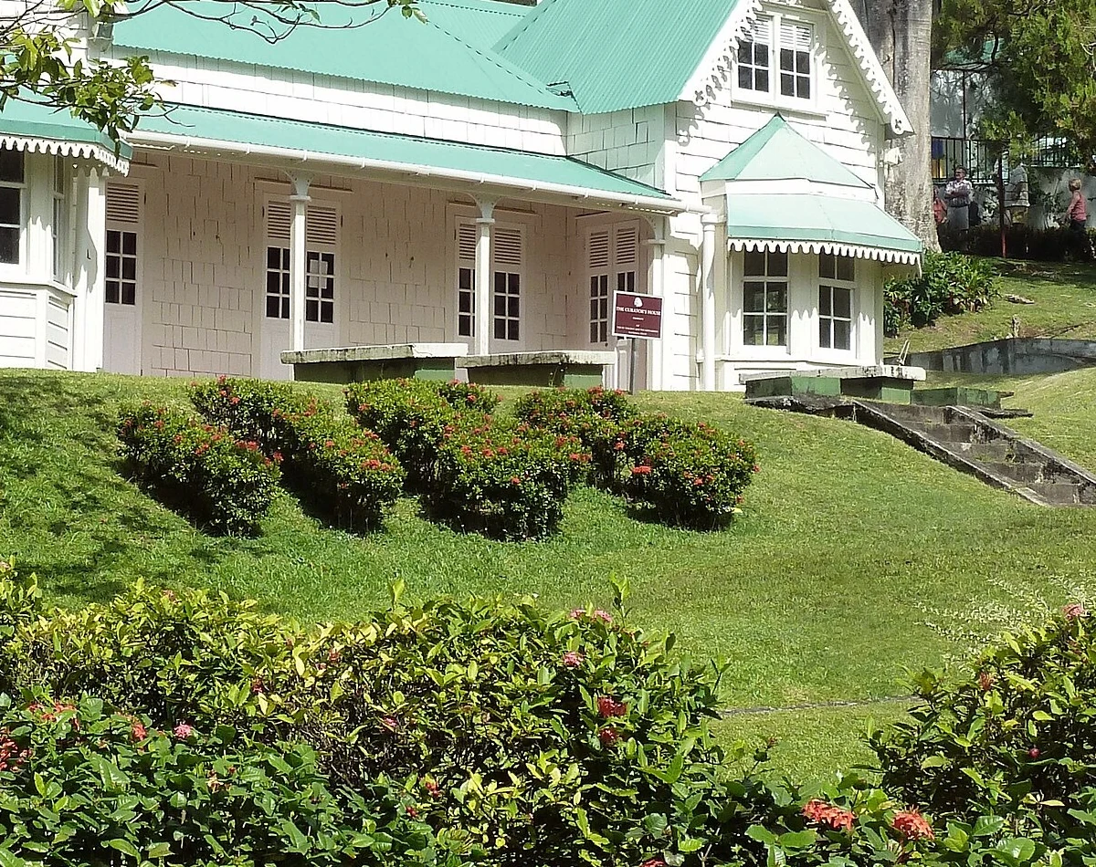 金斯敦在地地址標記。門前酒紅底小牌主行可讀 THE CURATOR HOUSE；下方細字無法可靠核讀，不補寫。此牌用屋名辨認建築，按在地地址標記收錄；來源慣稱 Curator’s House，本文不把來源標題反推成牌上可見的撇號。