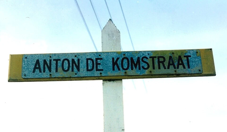 巴拉馬利波街名標記。牌面可讀ANTON DE KOMSTRAAT；STRAAT是荷蘭語的街，與人名連寫。