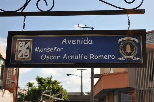 聖薩爾瓦多街名標記。可讀Avenida、Monseñor、Oscar Arnulfo Romero；Monseñor是宗教尊稱，整體街名含完整人名。