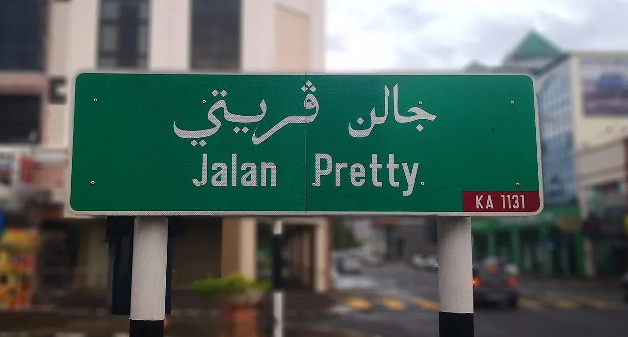 斯里巴加灣：綠牌上方為爪夷文，下方寫「Jalan Pretty.」，右下角紅格是「KA 1131」。