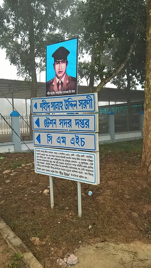 博古拉：最上方箭牌寫「শহীদ সালাহ উদ্দিন সরণী」（烈士Salahuddin紀念道路）；下兩格是軍營總部及CMH醫院。