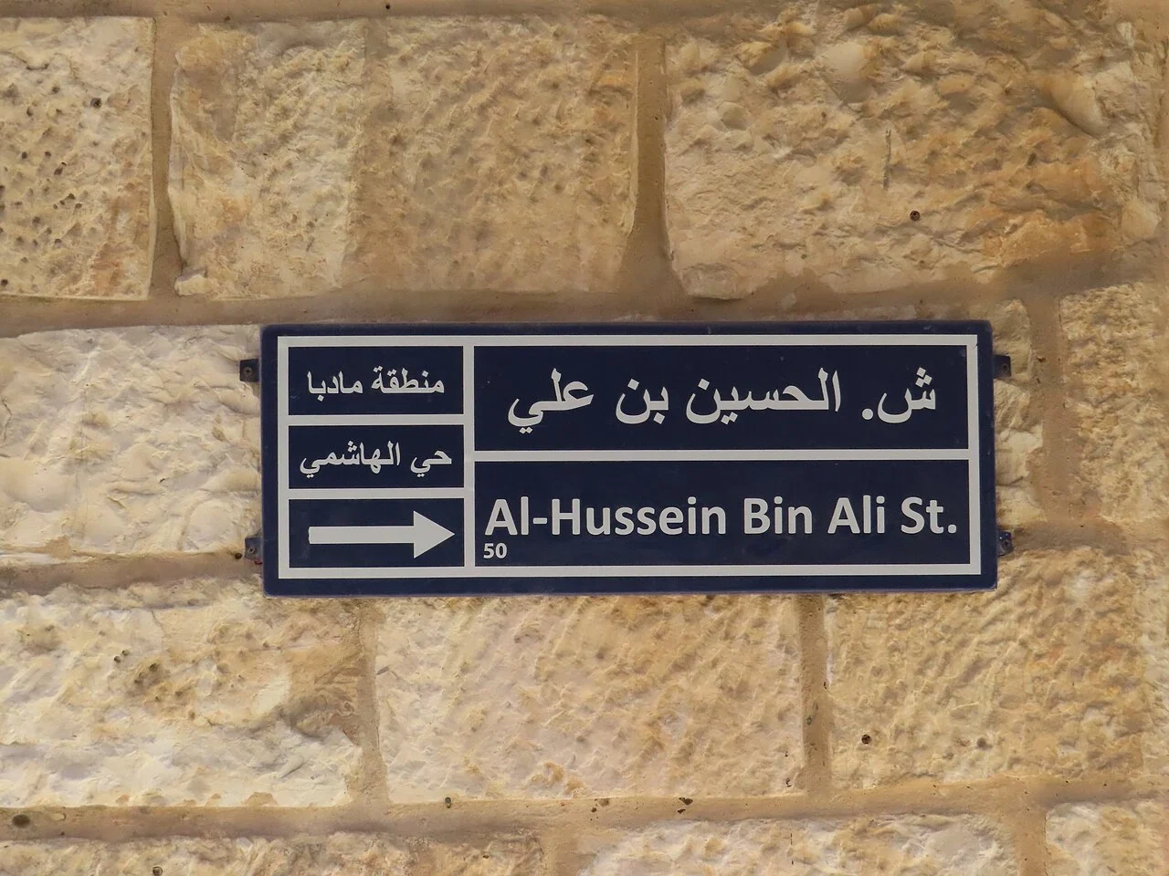 馬達巴:主要文字為「Al-Hussein Bin Ali St.」及阿拉伯文,英文行下有50;左側小格有地區文字及向右箭頭。