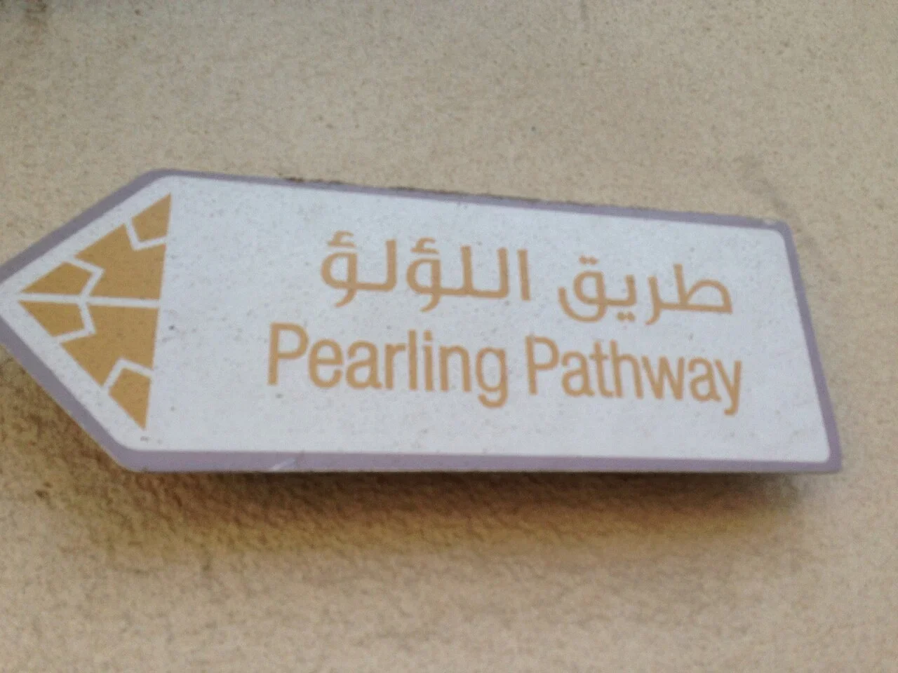 穆哈拉格：牌面寫「طريق اللؤلؤ／Pearling Pathway」，左端箭形內有放射狀圖案。