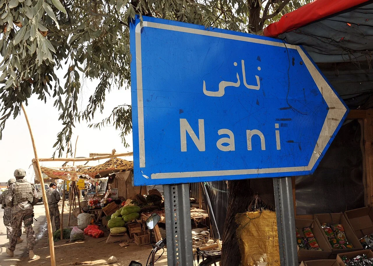 納尼：藍色右箭牌上行寫「نانی」，下行寫「Nani」；兩行指同一村落名稱。