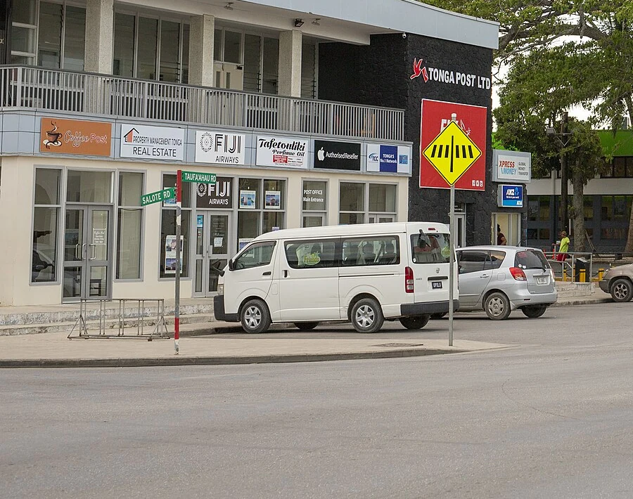 努庫阿洛法的實拍街名或地址牌。綠牌「SALOTE RD」與「TAUFA’AHAU RD」分別標示兩條實際道路；Rd為Road縮寫，後方商店招牌與交通警告牌各有不同用途。