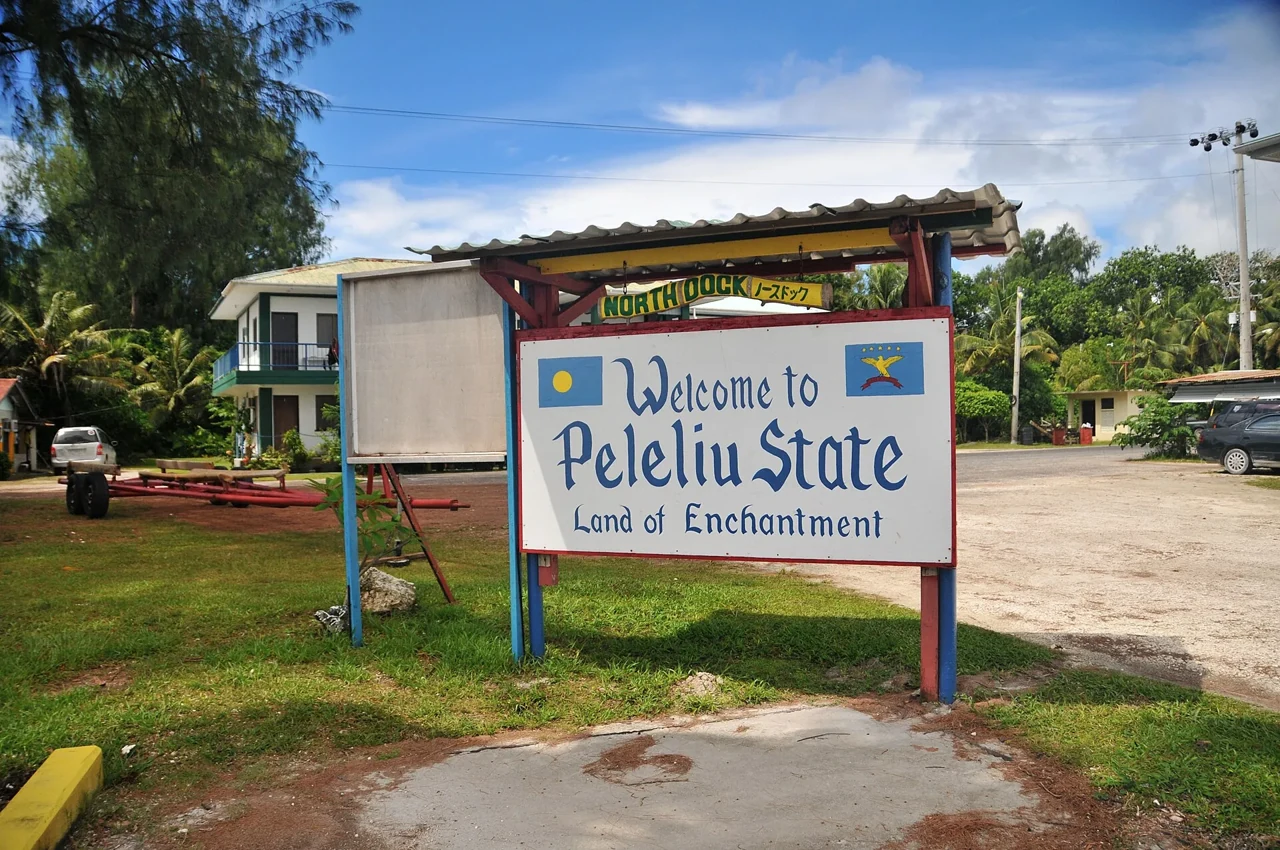 帛琉貝里琉北碼頭入口的Welcome to Peleliu State白底藍字牌，上方懸NORTH DOCK和日文碼頭名。