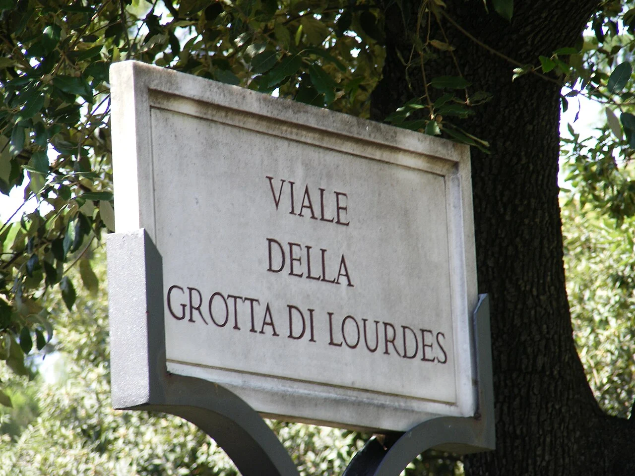 梵蒂岡城的實拍街名或地址牌。「VIALE DELLA GROTTA DI LOURDES」為梵蒂岡花園內道路名稱；Viale表示林蔭大道，並非景點方向單獨一詞。