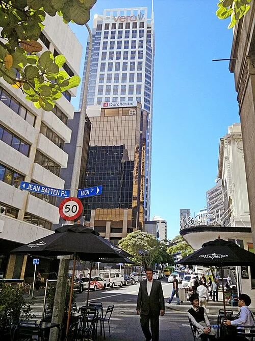 奧克蘭Shortland Street街角全景,左上方藍牌寫Jean Batten Pl與High St,下面有50速限牌,遠處為高樓與行人。
