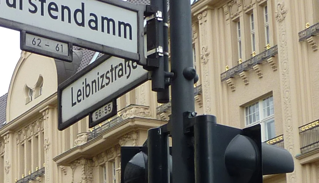 柏林立柱上的白底黑字Leibnizstraße街牌,下行寫56–55,旁邊可見另一街牌的一部分。