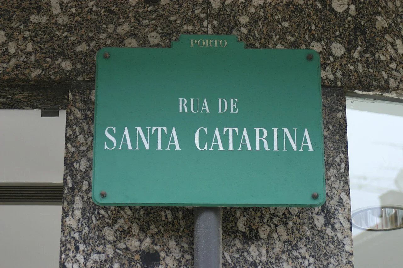 波多綠底白字Rua de Santa Catarina街牌，頂部凸起區寫Porto，背景為石材牆面。