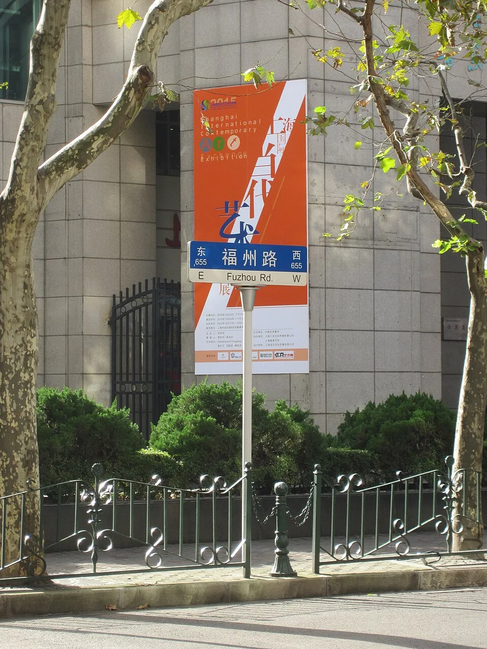 上海福州路街景，藍白色福州路路牌位於橘色宣傳看板前方，附有英文街名和方向資訊。