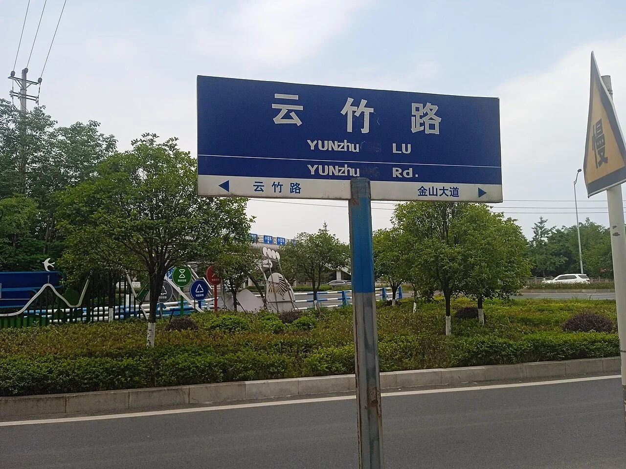 重慶：牌面寫「云竹路」，並列「Yunzhu Lu」「Yunzhu Rd.」；下緣箭頭指向相鄰道路。