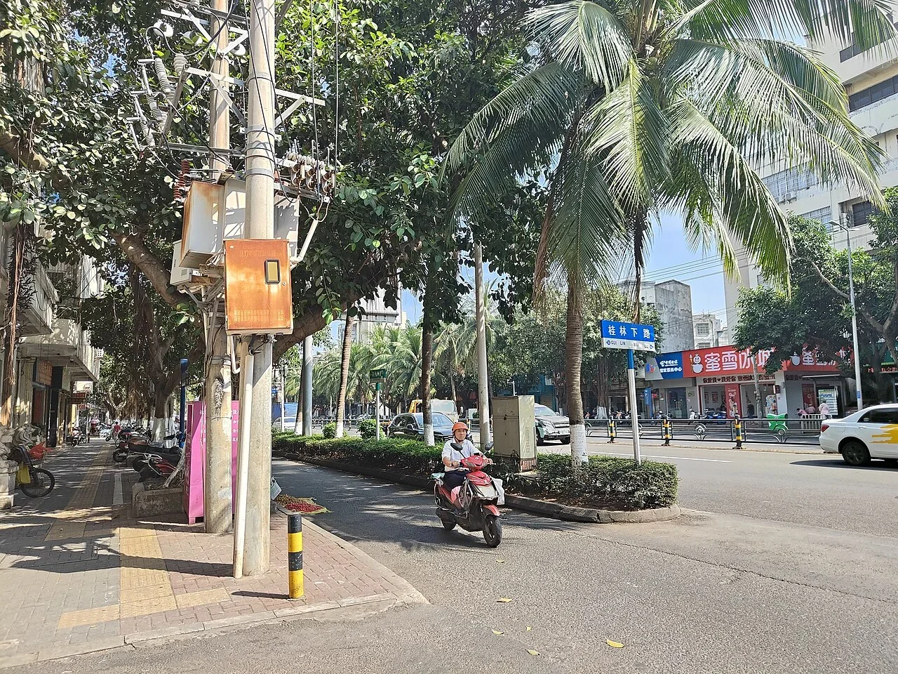 海口：照片路口的藍牌寫「桂林下路」並附拉丁字母，牌位於街景中景；沒有可確認的建築號碼。