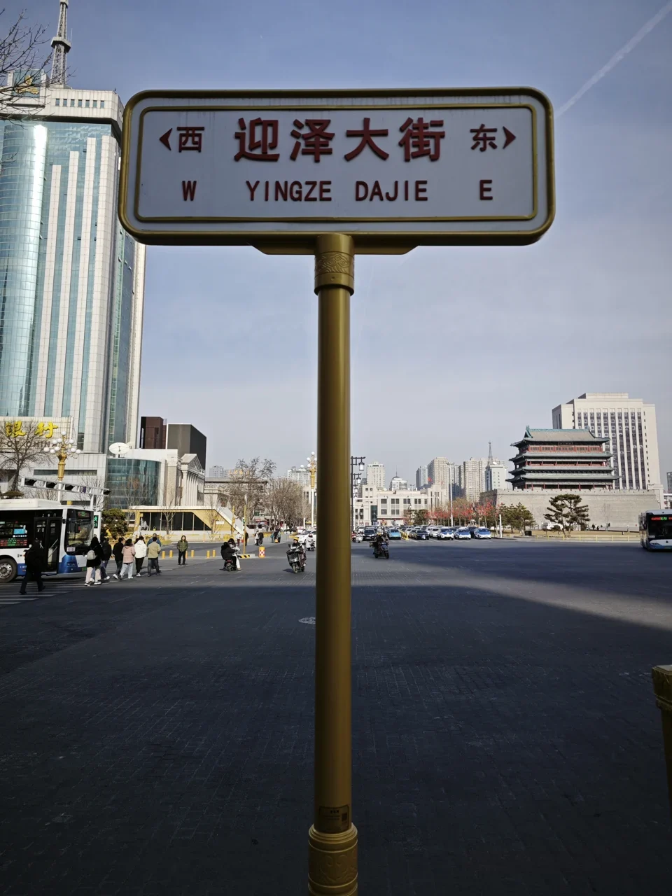 太原：白底牌寫「迎泽大街／YINGZE DAJIE」，兩端以西、東與W、E標方向。