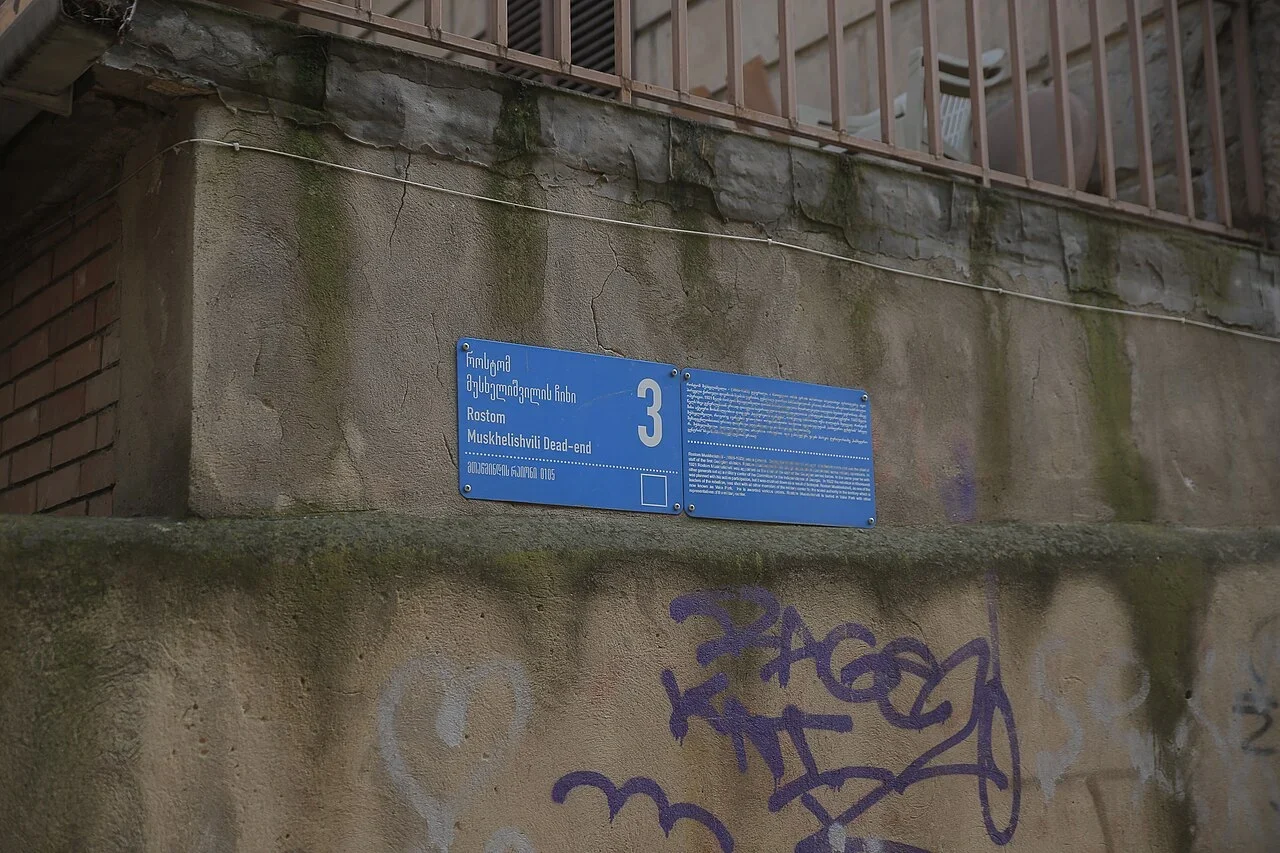 提比里斯：藍牌寫「Rostom Muskhelishvili Dead End」及3號；街名與門號分欄，右側另有小字地址資訊。