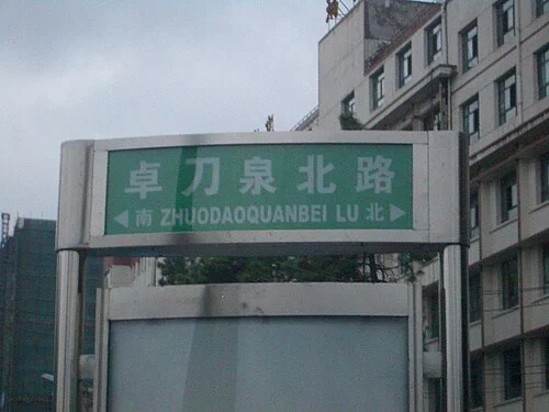 武漢：綠牌寫「卓刀泉北路／ZHUODAOQUANBEI LU」，兩側以「南」「北」與箭頭標示方向。