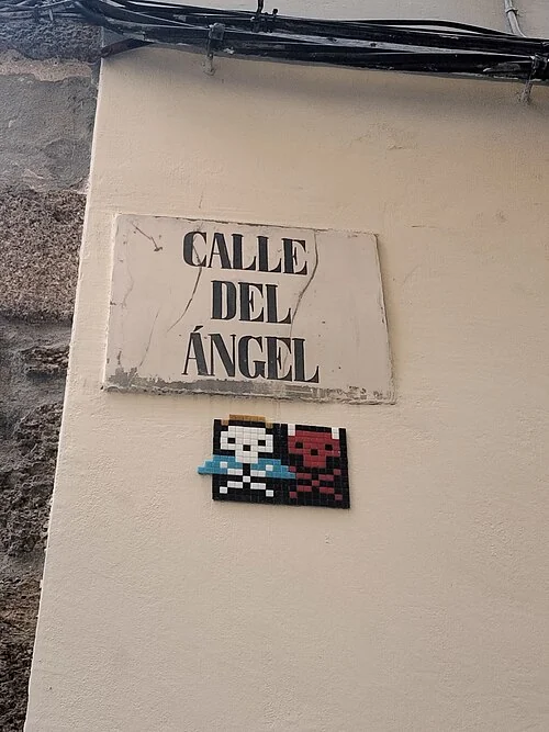拉科魯尼亞的實拍街牌。「CALLE DEL ÁNGEL」為天使街;下方彩色圖案不屬於街名文字。