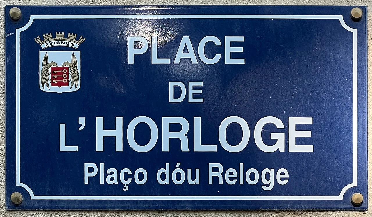 亞維儂的實拍街牌。「PLACE DE L’HORLOGE」為鐘樓廣場；下行「Plaço dóu Reloge」是另一種語言的對應名稱。
