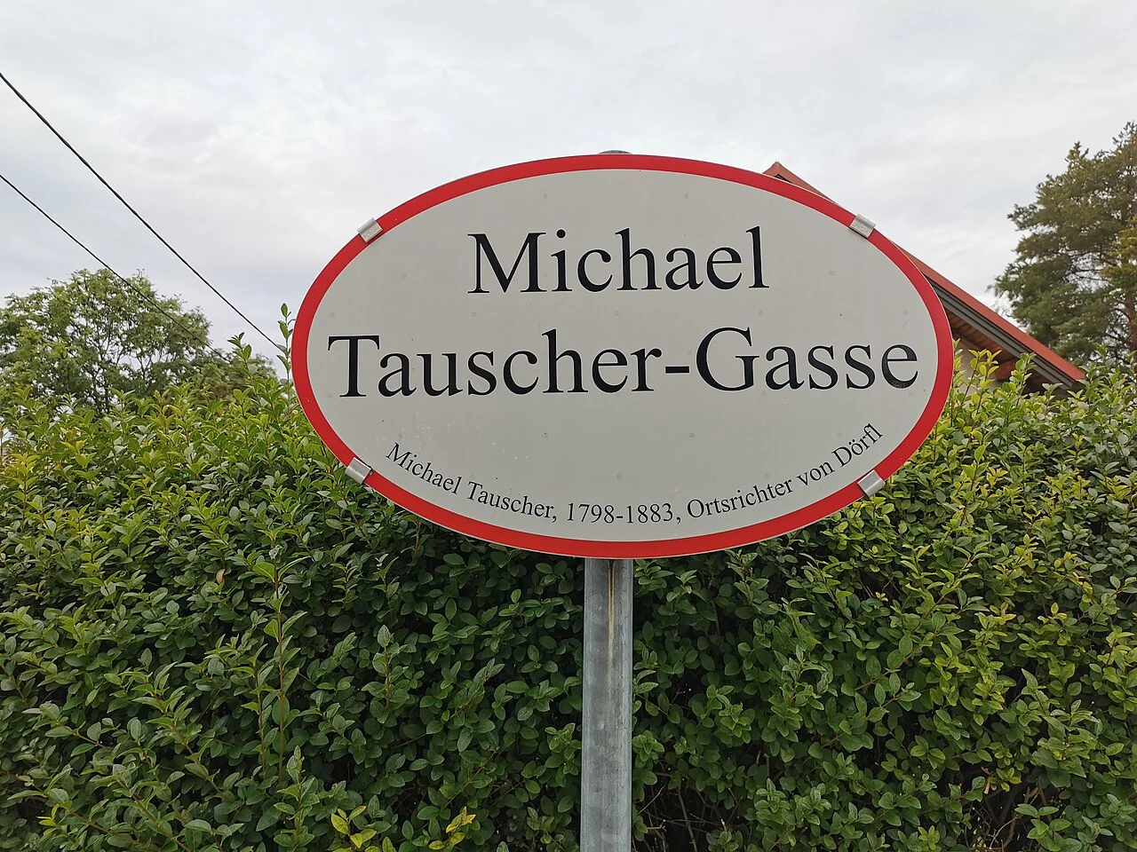 巴登（奧地利）的實拍街牌。「Michael Tauscher-Gasse」為街名；下緣另列人物資訊，數字屬生平說明而非門牌。
