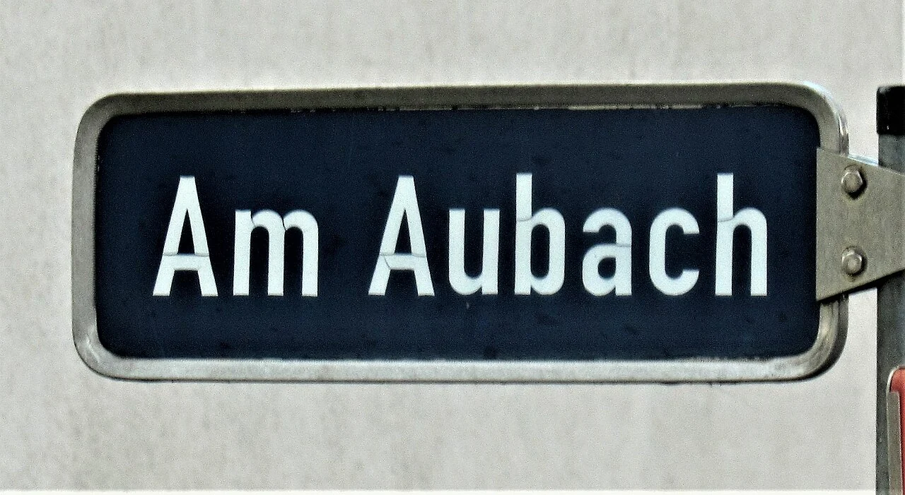 拜羅伊特的實拍街牌。「Am Aubach」為街名；Am是德語介詞與冠詞的合寫，畫面沒有門牌號碼。