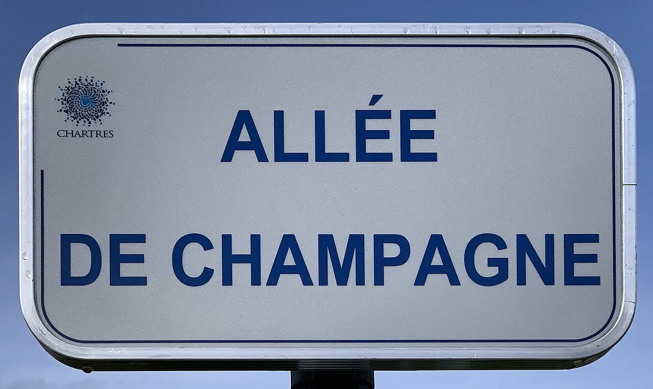 沙特爾的實拍街牌。「ALLÉE DE CHAMPAGNE」為道路名稱，左上另有Chartres城市標誌。