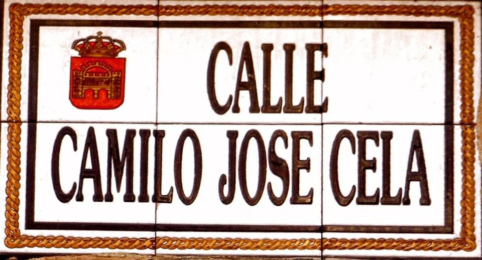 梅里達（西班牙）的實拍街牌。「CALLE CAMILO JOSÉ CELA」為街名；三部分姓名合讀，沒有門牌數字。