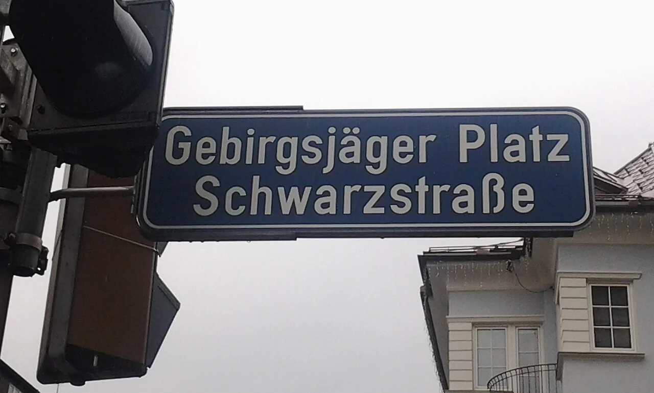 薩爾茲堡的實拍街牌。「Gebirgsjäger Platz」與「Schwarzstraße」是兩個道路名稱，共用一面轉角方向牌。