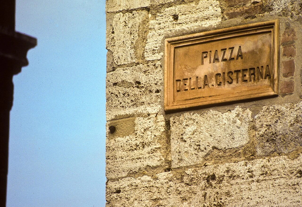 聖吉米尼亞諾的實拍街牌。「PIAZZA DELLA CISTERNA」為廣場名，Cisterna字面指蓄水池；此處不推定設施建造年份。