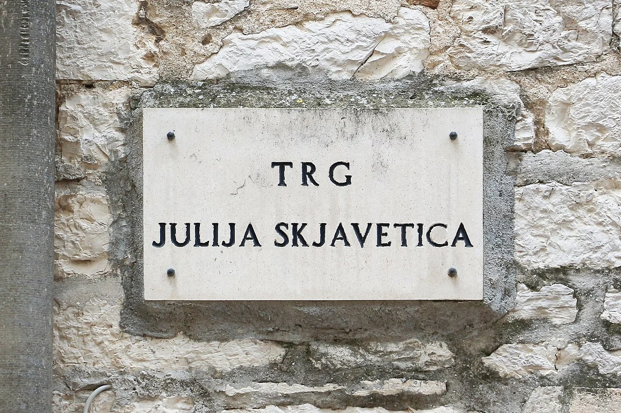 希貝尼克的實拍街牌。「TRG JULIJA SKJAVETIĆA」為廣場名稱；Trg表示廣場，並非人名的一部分。