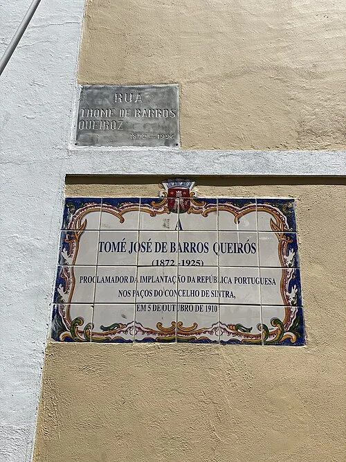 辛特拉的實拍街牌。上方舊街牌與下方解說牌對應「Tomé José de Barros Queiroz」的人名街；下牌生平文字不是地址。