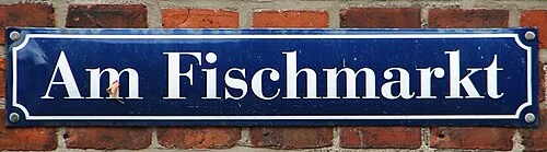 施特拉爾松德的實拍街牌。「Am Fischmarkt」為街名,字面指魚市場旁;此處不把字面意思當作市場創設年代的證據。