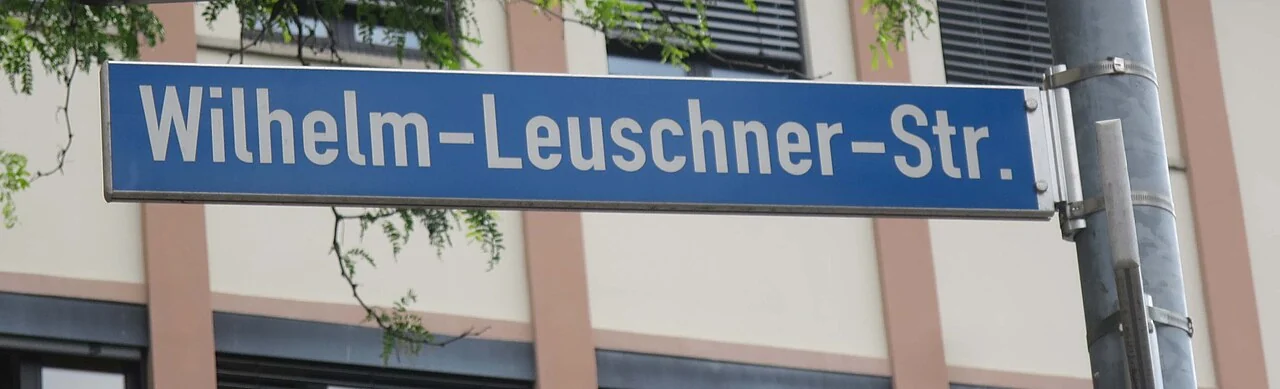 沃爾姆斯的實拍街牌。「Wilhelm-Leuschner-Str.」為街名；Str.是Straße的縮寫，連字號保留人名結構。