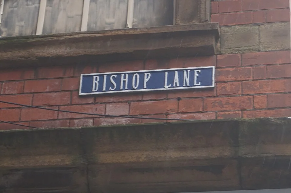赫爾河畔京斯頓的實拍街牌。BISHOP LANE 為街名；LANE為巷道通名。