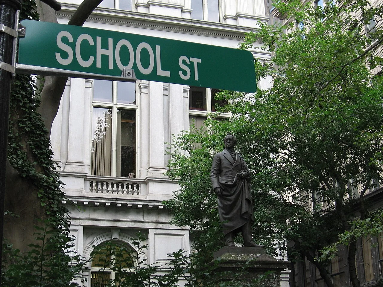 波士頓綠底白字SCHOOL ST街牌，後方可見舊市政廳立面、樹木及人物雕像。