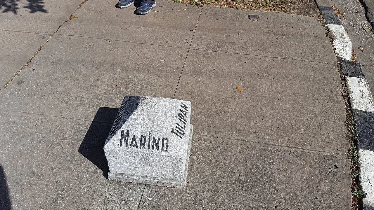 哈瓦那人行道上的淺灰色低矮路標,中央寫MARINO,右側斜向排列TULIPÁN,旁邊是路緣。
