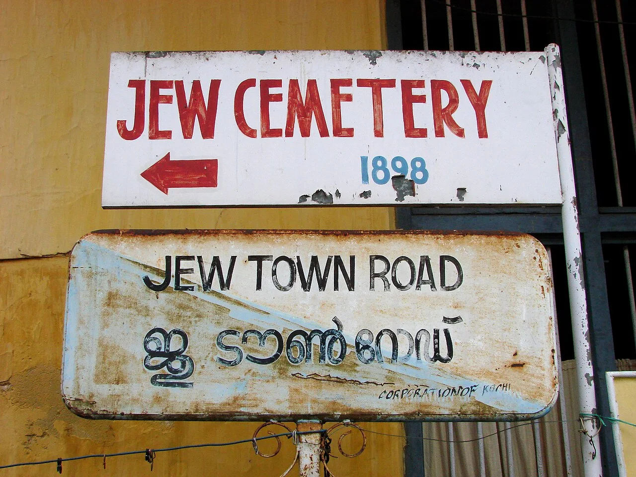 科欽 Jew Town Road 英文與馬拉雅拉姆文街名牌，上方另掛猶太墓園指示牌。