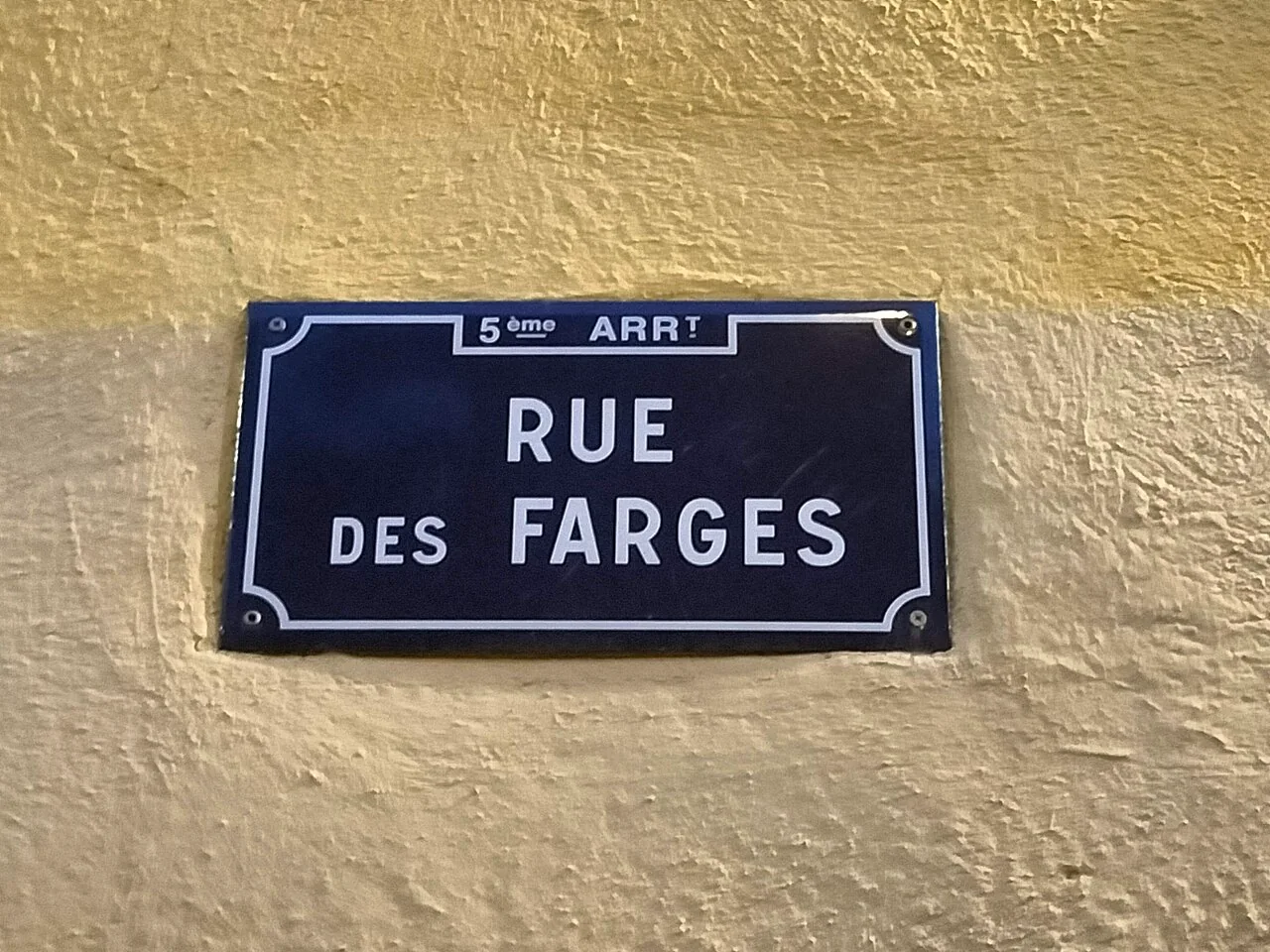 里昂黃牆上的深藍白框街牌，上緣寫第五區縮寫，中央寫RUE DES FARGES。