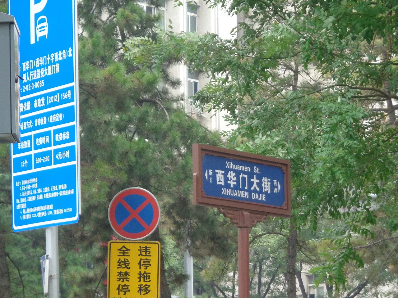 西安西華門大街藍底白字街牌，棕色裝飾框內附中英文、拼音與東西方位。