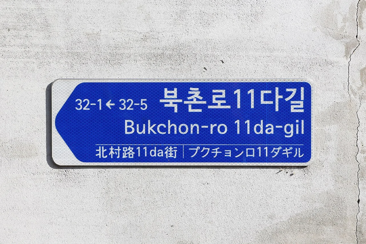 首爾北村牆面上的藍白街名牌，寫北村路11da街，並列韓文、羅馬字、中文與日文。