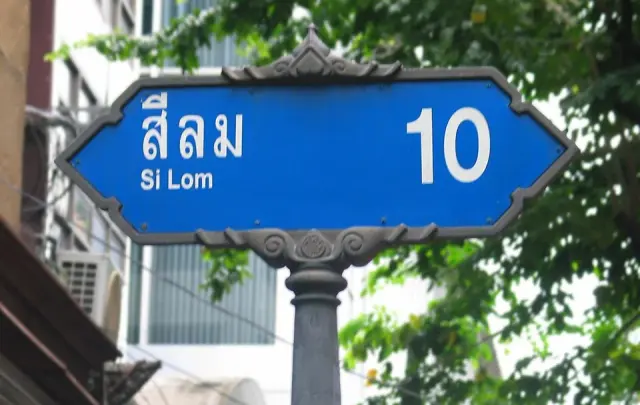 曼谷是隆路十巷的藍白街牌，泰文與 Si Lom 並列，右側有放大的數字10與灰色裝飾外框。