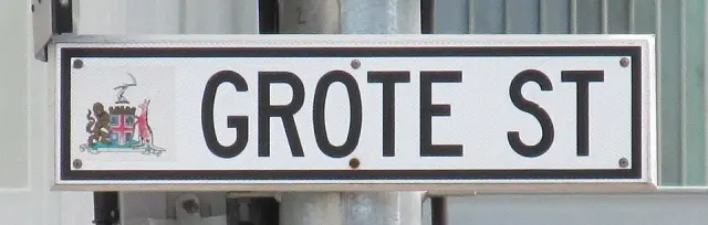 阿得雷德白底黑框GROTE ST街牌特寫，左端有彩色城市紋章，外圍為銀色框。