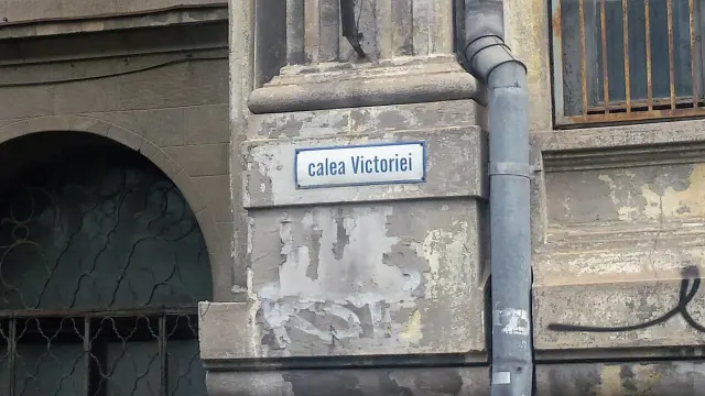 布加勒斯特灰色裝飾牆面上，白底藍框的小牌寫著calea Victoriei。