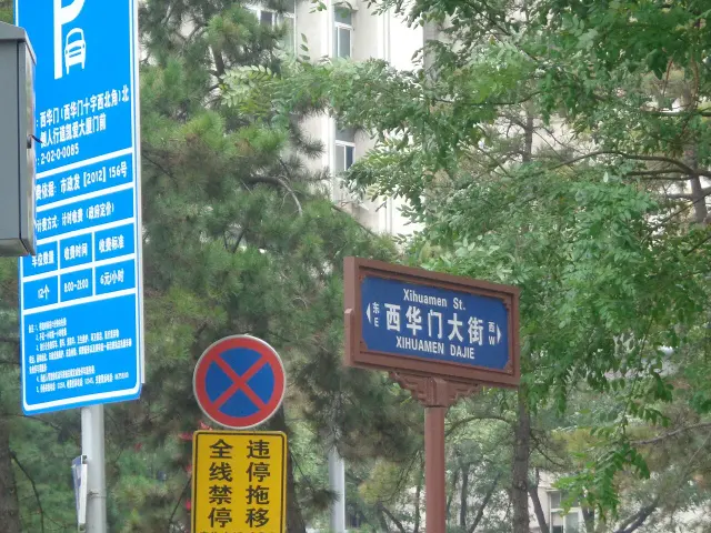西安西華門大街藍底白字街牌，棕色裝飾框內附中英文、拼音與東西方位。