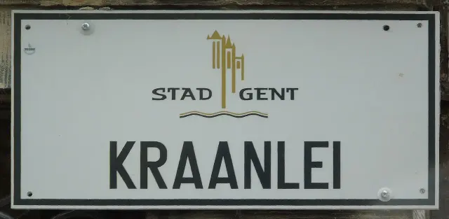根特的實拍街牌。「KRAANLEI」是河岸街名；上方「STAD GENT」意為根特市，金色圖形是城市識別。