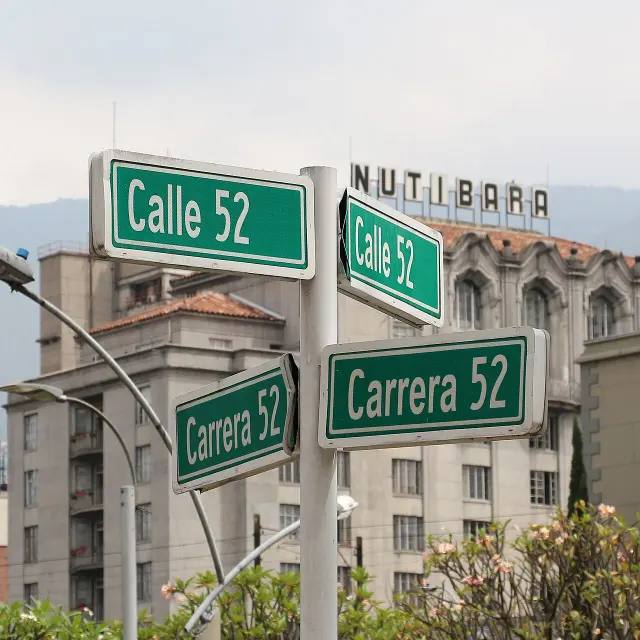 麥德林兩塊綠牌分別寫CALLE 52與CARRERA 52，背景為都市建築。
