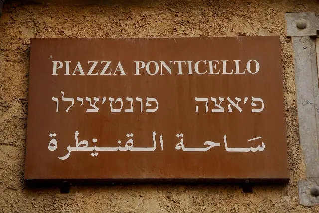 巴勒摩的實拍街牌。上行為義大利文「PIAZZA PONTICELLO」，中、下行分別使用希伯來字母與阿拉伯字母；原牌拼寫完整保留。